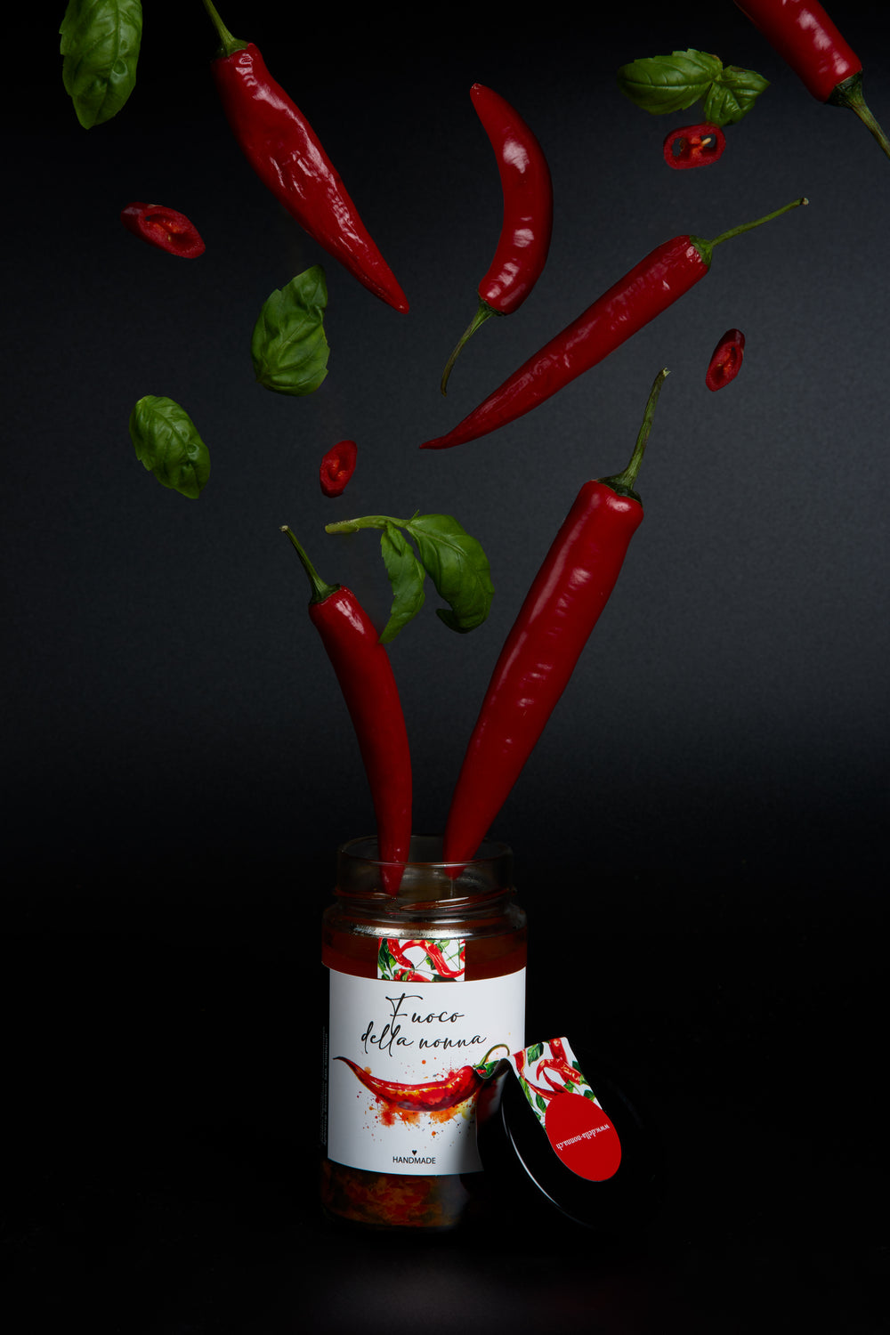 Offenes Glas Fuoco della Nonna mit roten Chilis und Basilikum